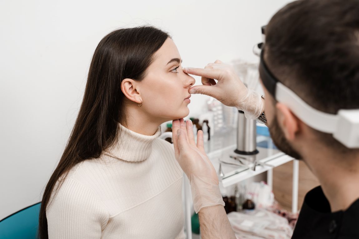 surgeon measuring patient's nose for rhinoplasty